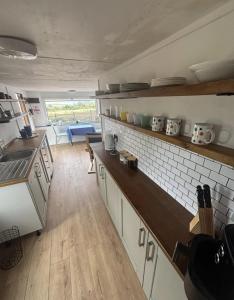 a kitchen with white cabinets and a wooden floor at Chi Byghan in Gulval