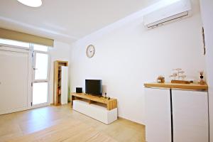 Ein Wohnzimmer mit einem Fernseher an einer weißen Wand in der Unterkunft Pertus in Follonica + 17 Fotos