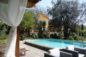 a swimming pool with chairs and a house at maison florentine in La Gaude