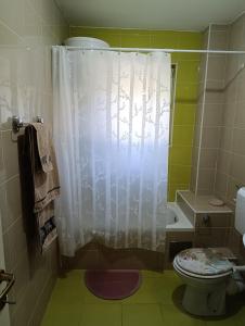 a bathroom with a white shower curtain and a toilet at Apartman Angela in Foča +8 photos