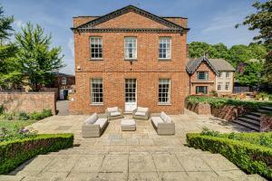 a brick building with couches in front of it at Abbey House by Group Retreats in Saffron Walden