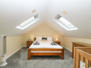 a bedroom with two skylights and a bed at 5 Ger Afon in Pwllheli