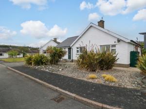 a white house with plants in front of it at 5 Ger Afon in Pwllheli