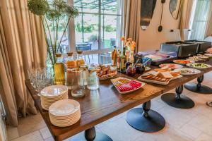 a wooden table with plates and food on it at Gamtos Perlas in Karklė