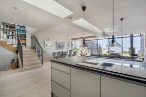 eine offene Küche und ein Wohnzimmer mit Treppe in der Unterkunft Beach House in Croyde