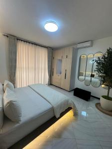 a bedroom with a large white bed in a room at Home in Naalya in Kampala