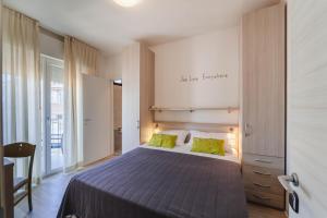 a bedroom with a large bed with green pillows at Hotel Anny in Lido di Jesolo +73 photos