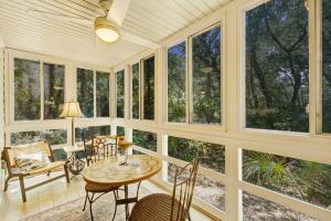 a screened in porch with a table and chairs and windows at Seascape 3522 in Kiawah Island +16 photos