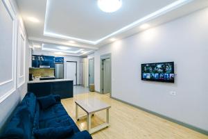a living room with a blue couch and a table at Bea Paradise 112 in Baku