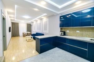 a kitchen with blue cabinets and a living room at Bea Paradise 112 in Baku