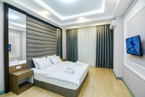a bedroom with a large bed and a tv at Bea Paradise 112 in Baku