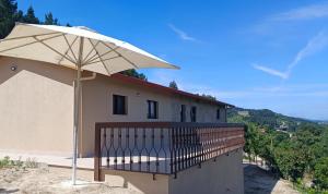 a white umbrella sitting on the side of a building at Casa do Maninho in Amarante