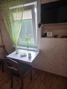 ein Zimmer mit einem Tisch und einem Fenster in der Unterkunft Pas tetulę in Anykščiai