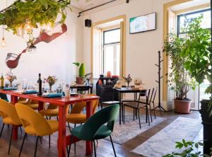 a restaurant with tables and chairs and plants at Ambiente Hostel in Lisbon