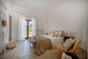 a white bedroom with a bed and a window at Oltre i coni in Santa Lucia +24 photos
