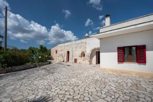 a white building with red shutters on it at Oltre i coni in Santa Lucia