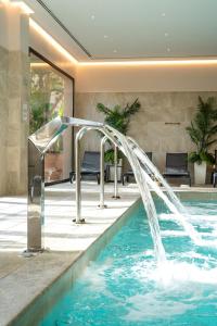 a pool with a water fountain in a house at Hotel Alicante Golf in Alicante