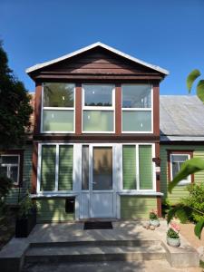 ein Haus mit großen Fenstern und einer Tür in der Unterkunft Pas tetulę in Anykščiai