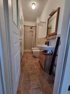 a bathroom with a sink and a toilet and a mirror at Ca' Sinoira in Nizza Monferrato