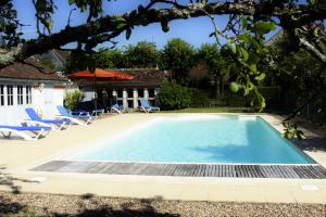 - une piscine dans une cour avec des chaises et une maison dans l'établissement Manoir de la Voute maison d'hôtes, à Pouillé