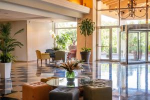 a lobby with a table and chairs and plants at Hotel Alicante Golf in Alicante +58 photos