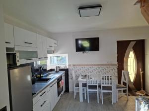 a kitchen with white appliances and a table and chairs at Dom Trakt Słupski Sulęczyno in Sulęczyno