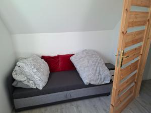 a bed with pillows on it in a room at Dom Trakt Słupski Sulęczyno in Sulęczyno