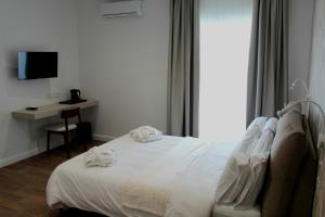 a bedroom with a bed and a desk and a television at Balzanija Boutique Accommodation in Balzan