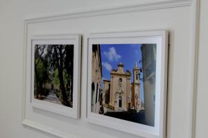 two framed photographs of a church on a wall at Balzanija Boutique Accommodation in Balzan