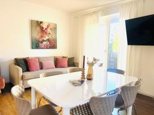 a living room with a white table and a couch at APSTAY Bungalow I Parking option & Self Check-in in Graz