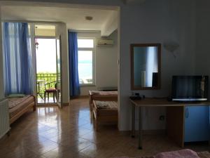 a living room with a television and a table with a mirror at Hotel Riva in Stenje