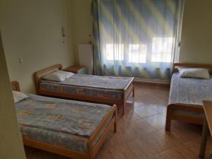 a room with three beds and a window at Hotel Riva in Stenje