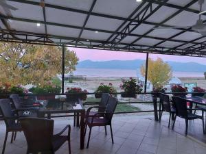 a patio with tables and chairs and a view of the ocean at Hotel Riva in Stenje