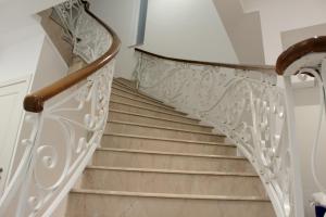 a staircase with white railings and wood floors at Balzanija Boutique Accommodation in Balzan