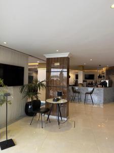 a lobby with a table and chairs and a kitchen at سراة للشقق الفندقية in Al Namas