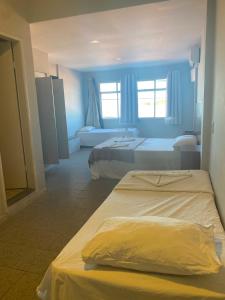 a hotel room with two beds and a window at Piúma Palace Hotel in Piúma +45 photos