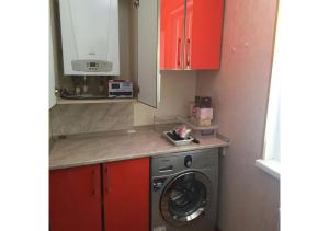 a washing machine in a kitchen with red cabinets at Forest Edge Guesthouse in Aghavnadzor +10 photos