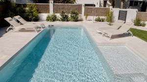 a swimming pool with chairs and a swimming pool at Villa Guvalmar Chalet Roche in Roche