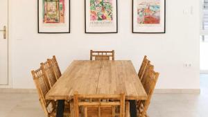 a wooden table and chairs in a room with paintings at Villa Guvalmar Chalet Roche in Roche +28 photos