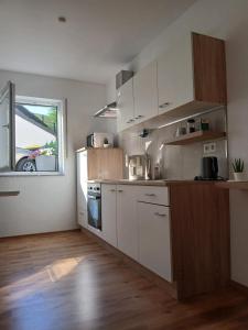 a kitchen with white cabinets and a window at Wohlfühloase mit Sauna in Mayen