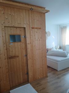 a room with a wooden wall with a bed and a door at Wohlfühloase mit Sauna in Mayen