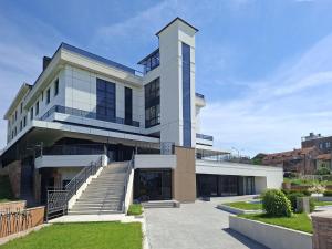 a large white building with stairs in front of it at Tailormade Hotel Median Niš in Niš