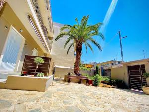 a palm tree in a courtyard next to a building at Phoenix Garden Apartments - 4 - in Athens