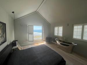 ein Schlafzimmer mit einem Bett und einer Badewanne in der Unterkunft Beach House in Croyde