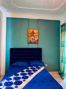 a bedroom with a bed with a blue wall at Renova-Immo in Yaoundé