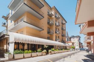 a building with a row of benches in front of it at Hotel Anny in Lido di Jesolo