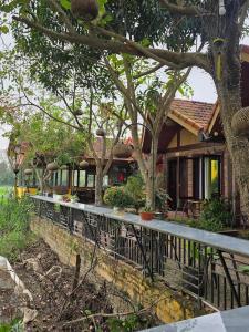 a house with a fence and some trees at L'Ananas Garden Homestay in Vũ Lâm