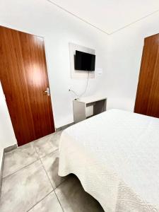a bedroom with a bed and a flat screen tv at HOTEL ITAPUÃ vg in Várzea Grande