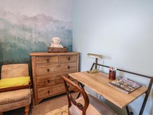 a room with a desk and a dresser and a chair at The Dacha in Winchester