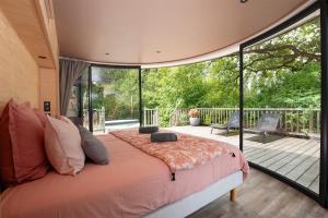 a bedroom with a large bed and a large window at LES 2 CABANES in Labastide-Gabausse